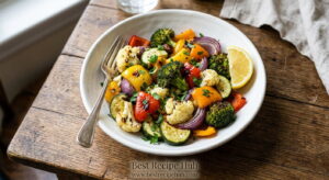 Healthy mixed air fryer vegetables served in a white bowl garnished with fresh parsley and lemon, ready to eat