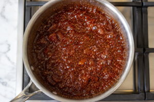 Fig jam reducing and bubbling in a saucepan on the stove